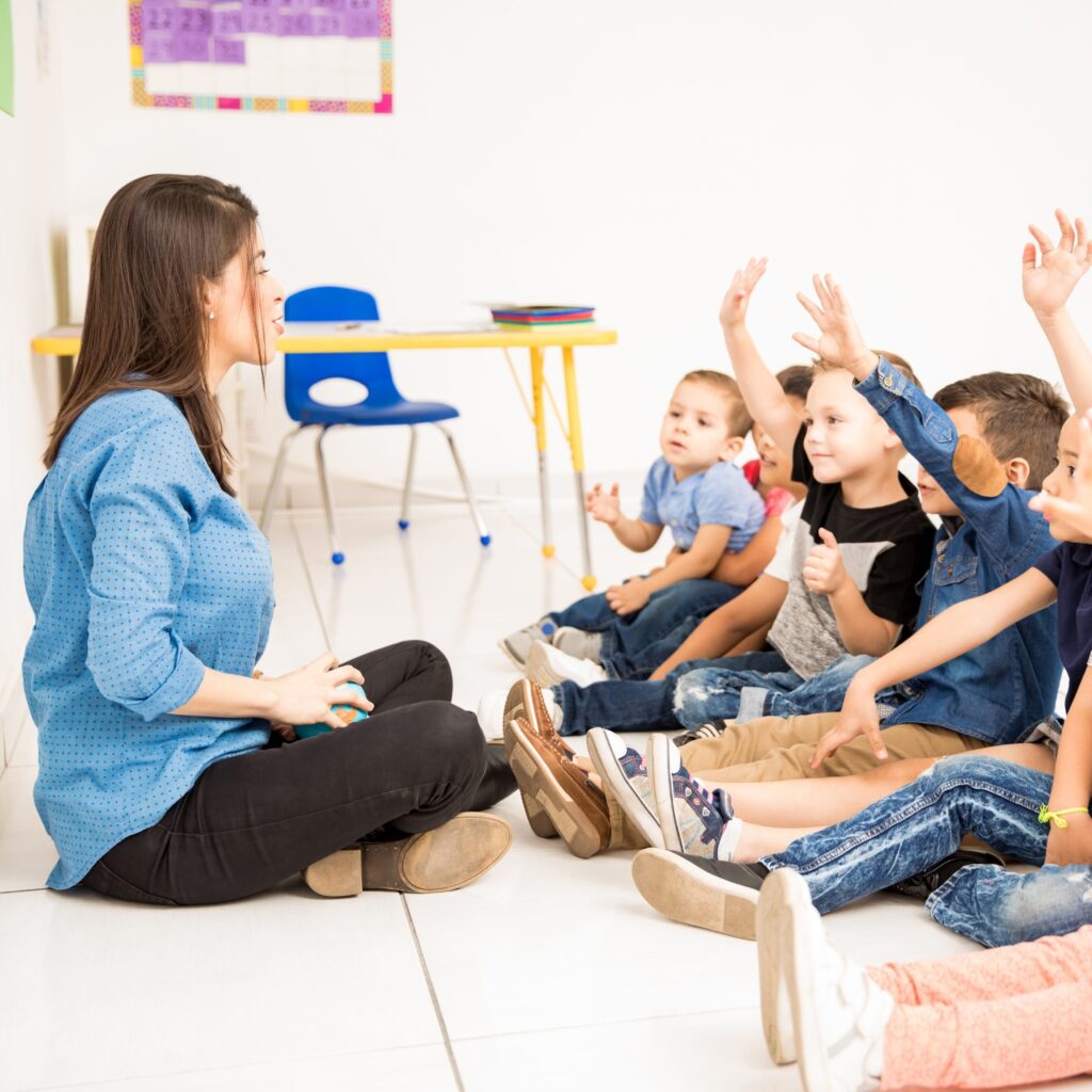 Preschool students raising their hands